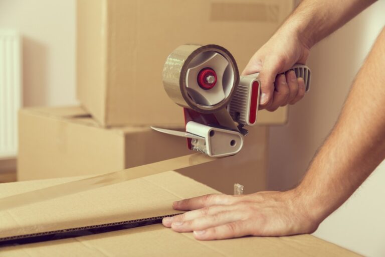 Closeup of hands with packing tape packaging moving boxes
