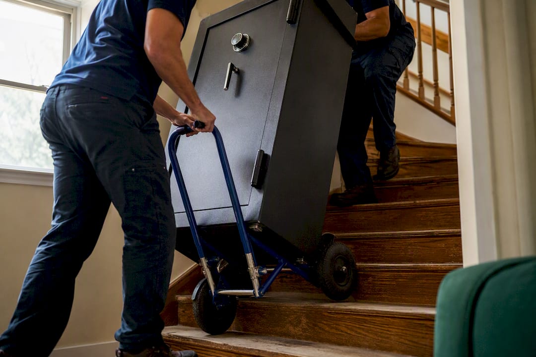 Movers navigating gun safe down stairs