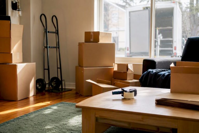 Packed moving boxes and dolly in living room